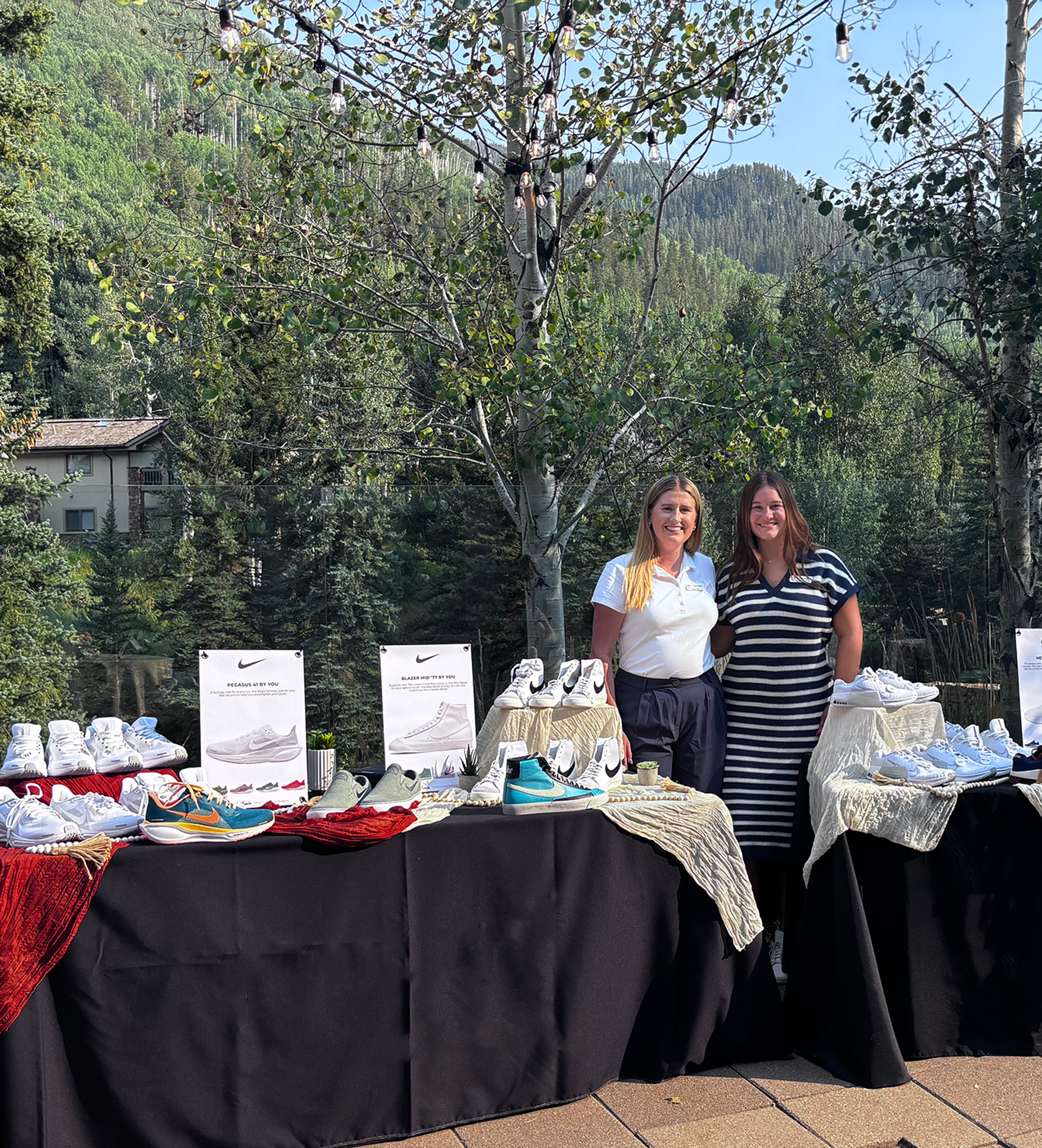 Two Global Evento Employees stand in front of a shoe display at an event hosted in Vail, Colorado.